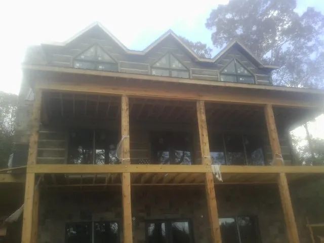 Dormers and porch framing on a large log home under construction — Roof Coating work by our crew in Big Bar