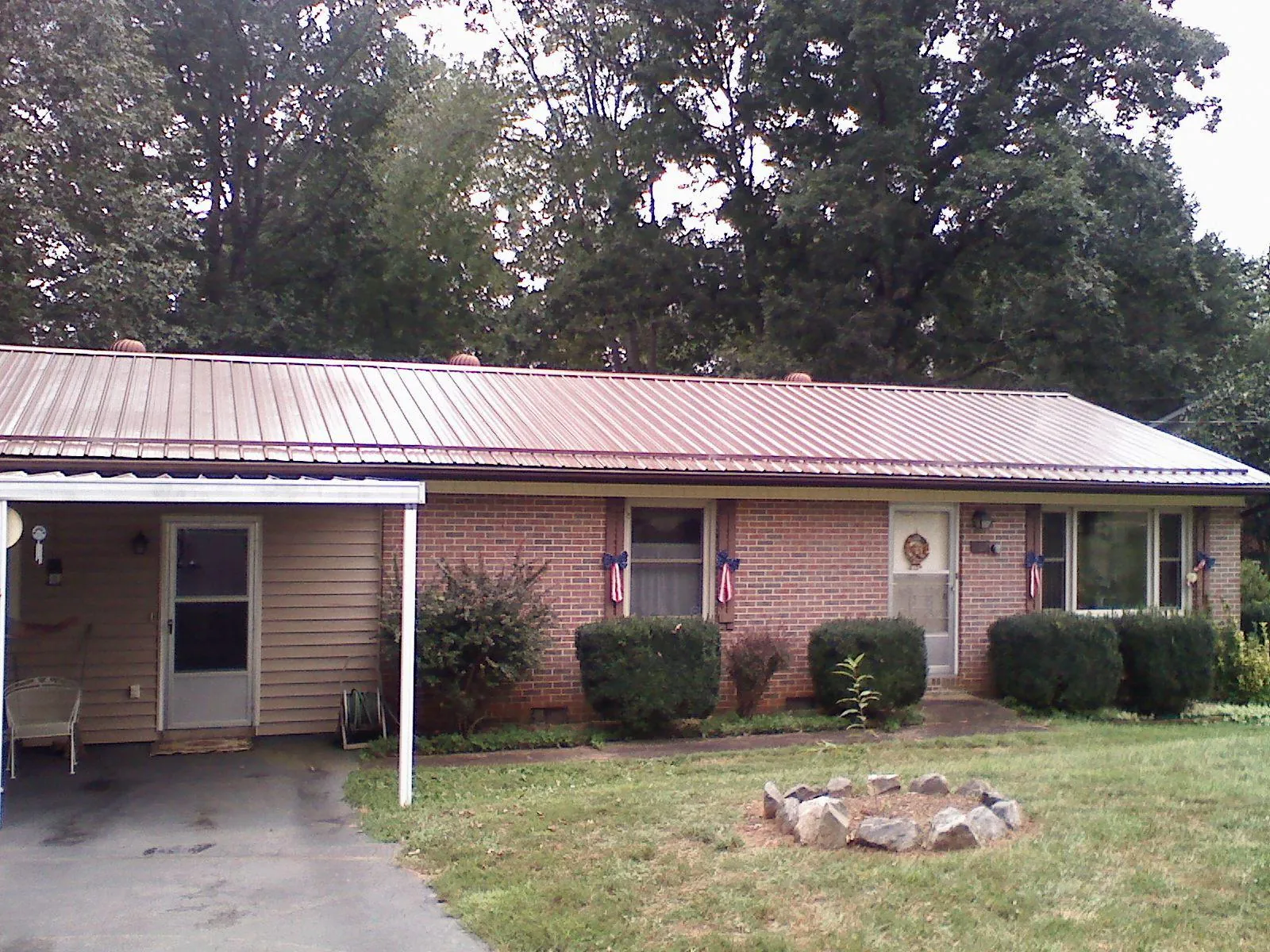 Bronze metal roof and carport on a brick ranch home — Roof Repair work by our crew in Big Bar